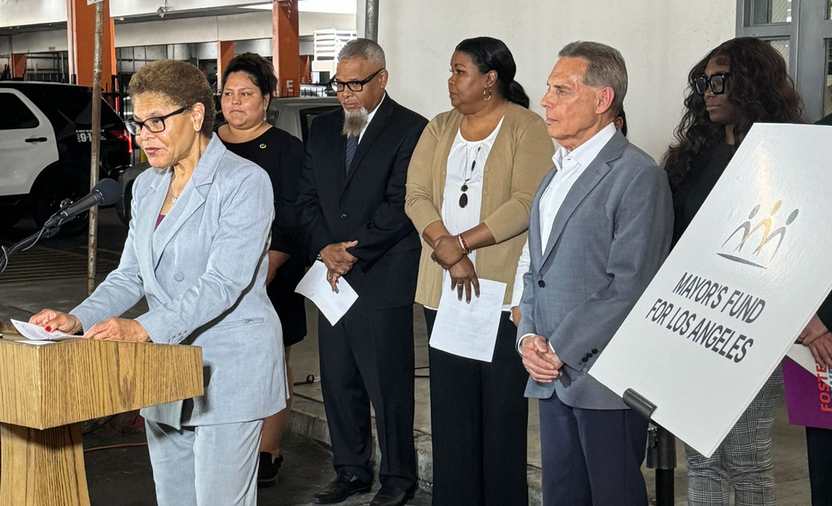 Mayor Karen Bass, speaking at a podium about serving young adults in foster care, in front of MFLA President and CEO Conway Collis and community members